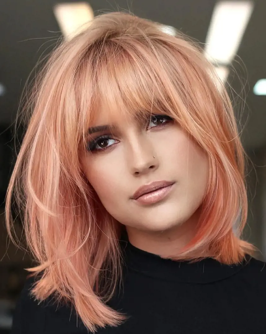 Flamingo Pink Bob with Layers and Bangs is a modern haircut for shoulder length hair.