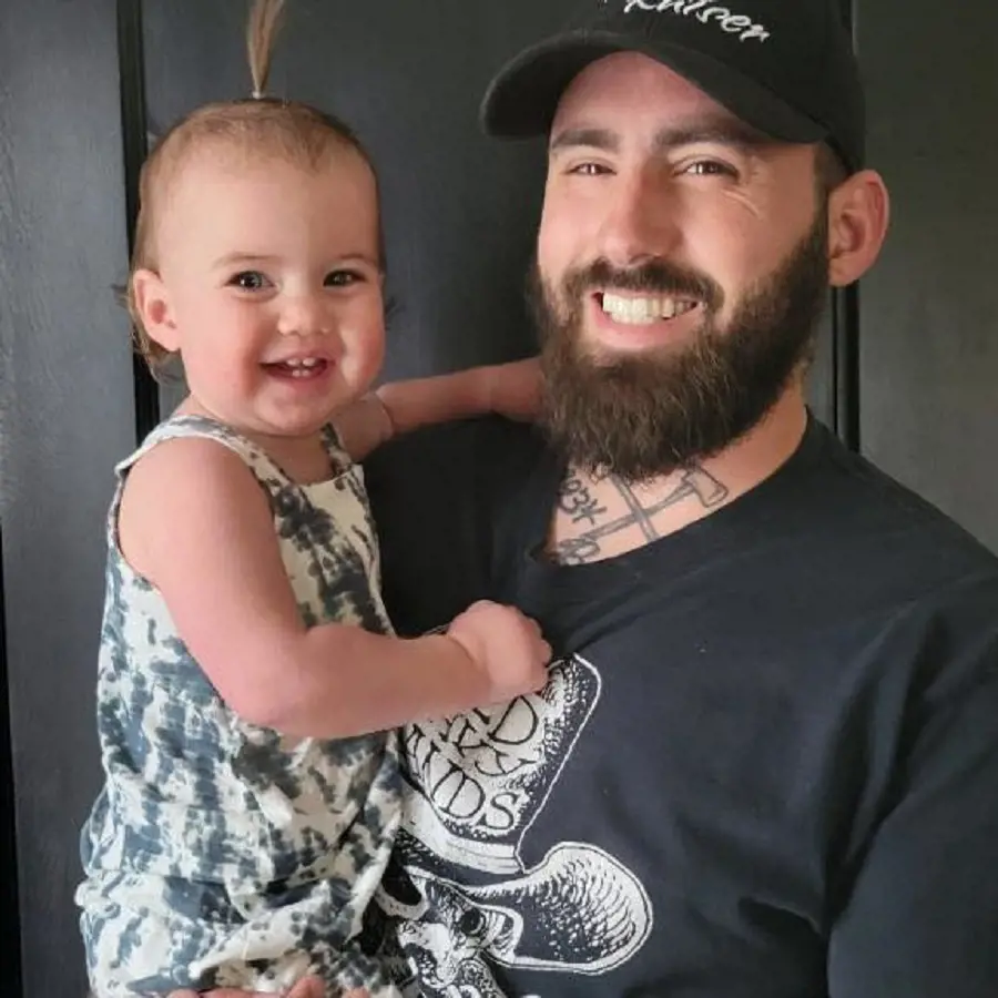Aaron smiling along with his young daughter. 