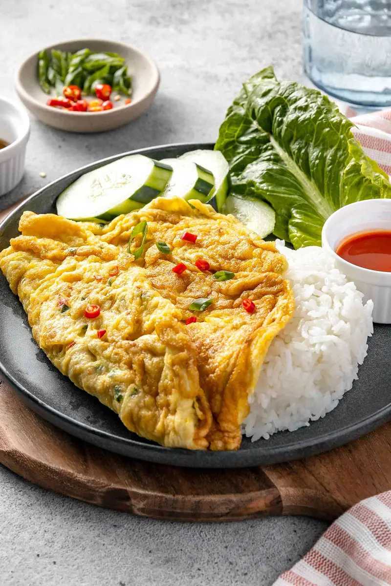 This classic Tha omelet kai Jeow is served with rice and raw greens for a satisfying meal