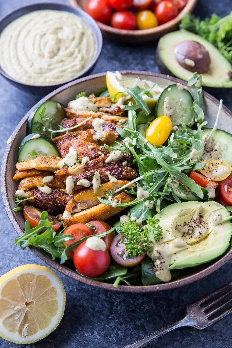 This crispy Mediterranean Chicken Salad by The Roasted Root combines fresh vegetables with zesty lemon herb tahini dressing