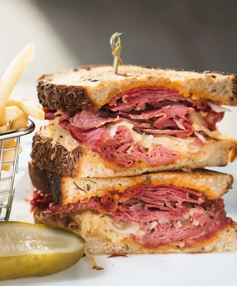 A classic Reuben sandwich made with corned beef, Swiss cheese, and sauerkraut piled high on bread